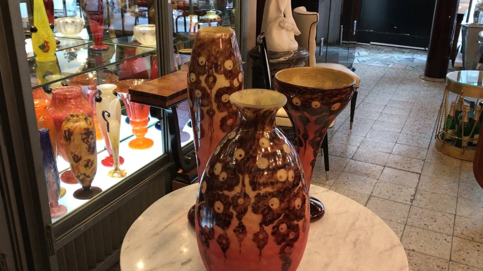 Tres jarrones antiguos de vidrio decorados en exhibición