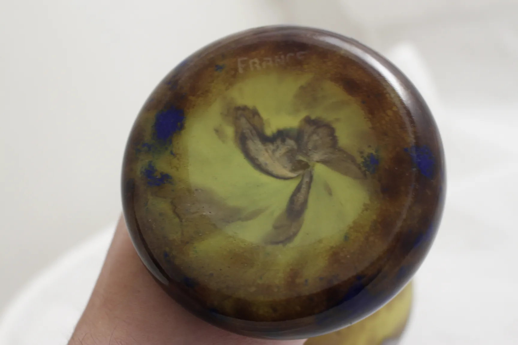 View of the bottom of a signed glass Le Verre with colorful touches and a visible signature.