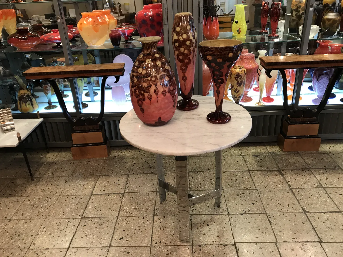 Vidrio antiguo firmado Le Verre francés en exhibición con otros objetos