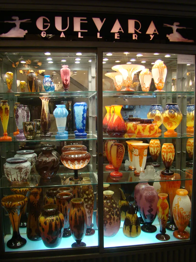 Vitrine mit Antiquitäten aus signiertem Glas Le Verre in verschiedenen Formen und Farben.