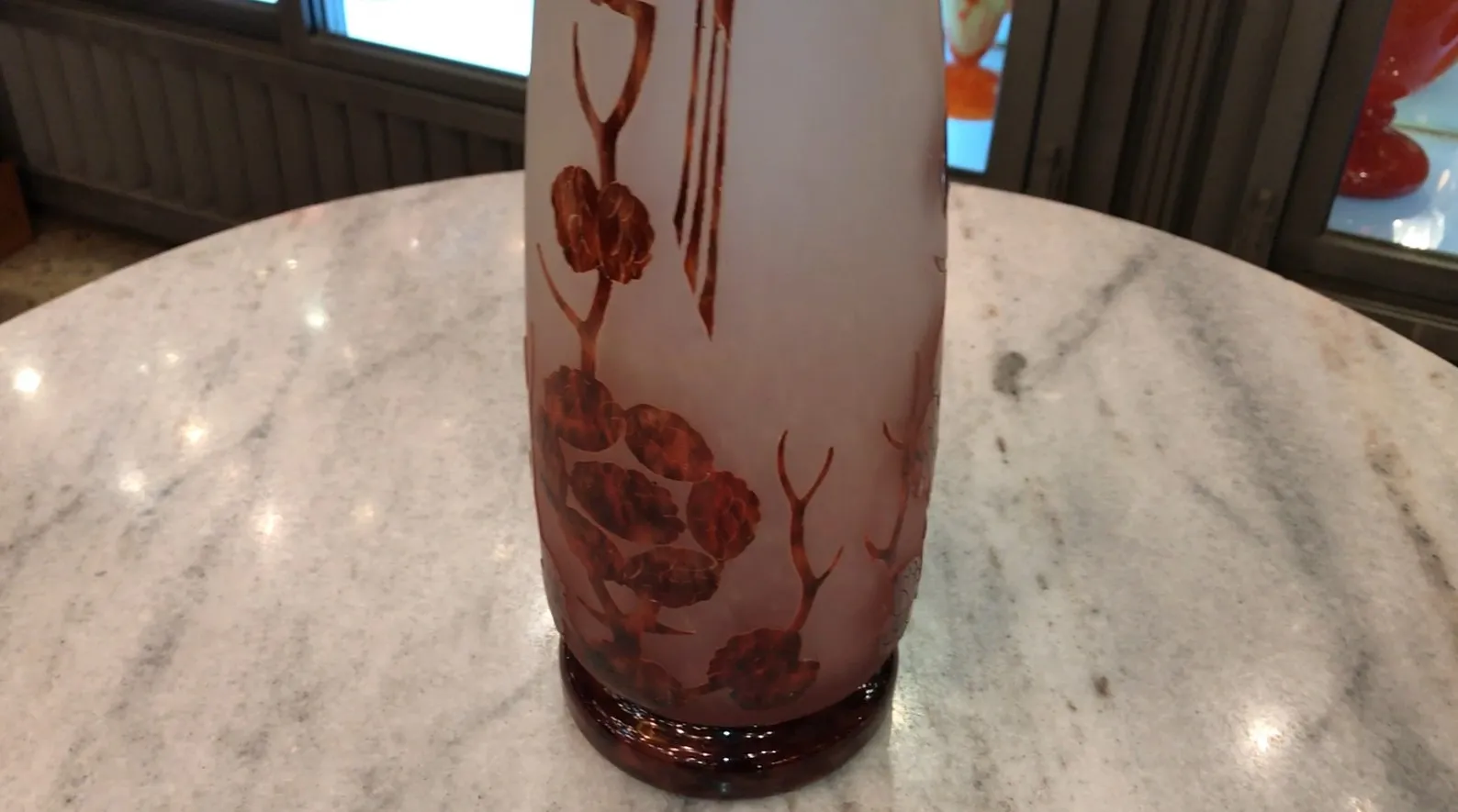 Vetro firmato Le Verre con design decorativo e dettagli artistici in un ambiente antico.