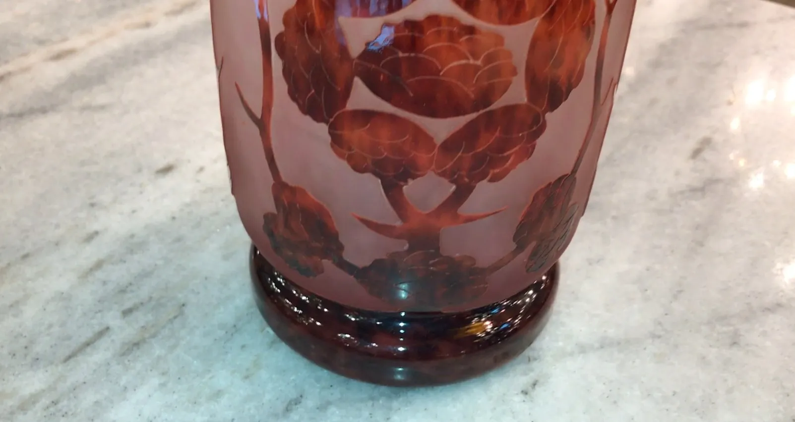 Vidrio firmado Le Verre con diseño floral en tonos cálidos sobre fondo claro.