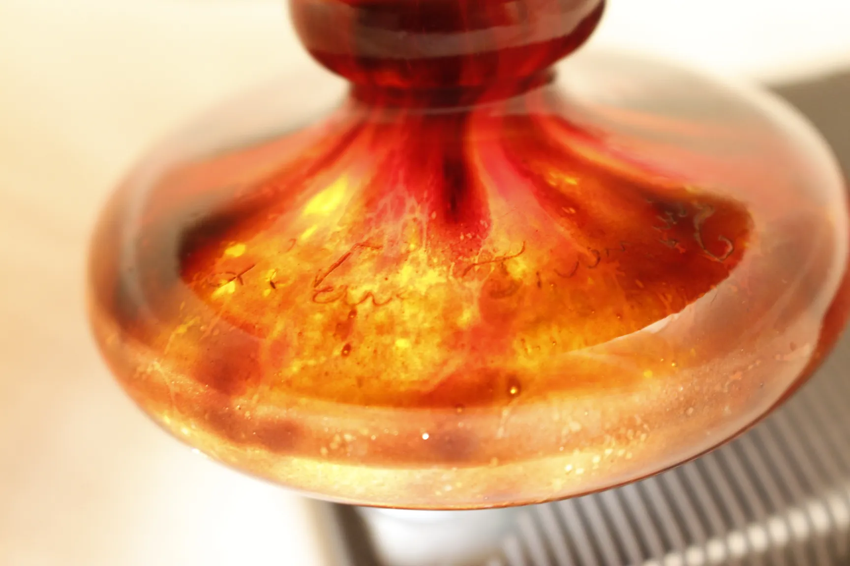 Verre signé Le Verre avec un design floral coloré dans un cadre ancien.