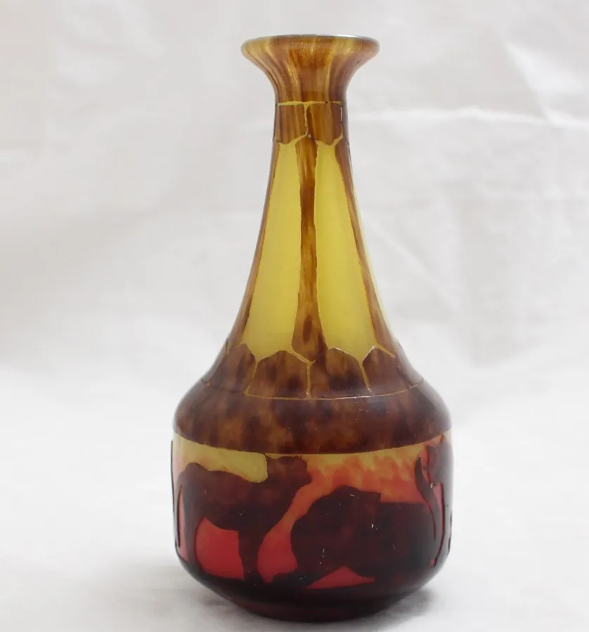 Antique glass bottle signed Le Verre with warm decorative colors.