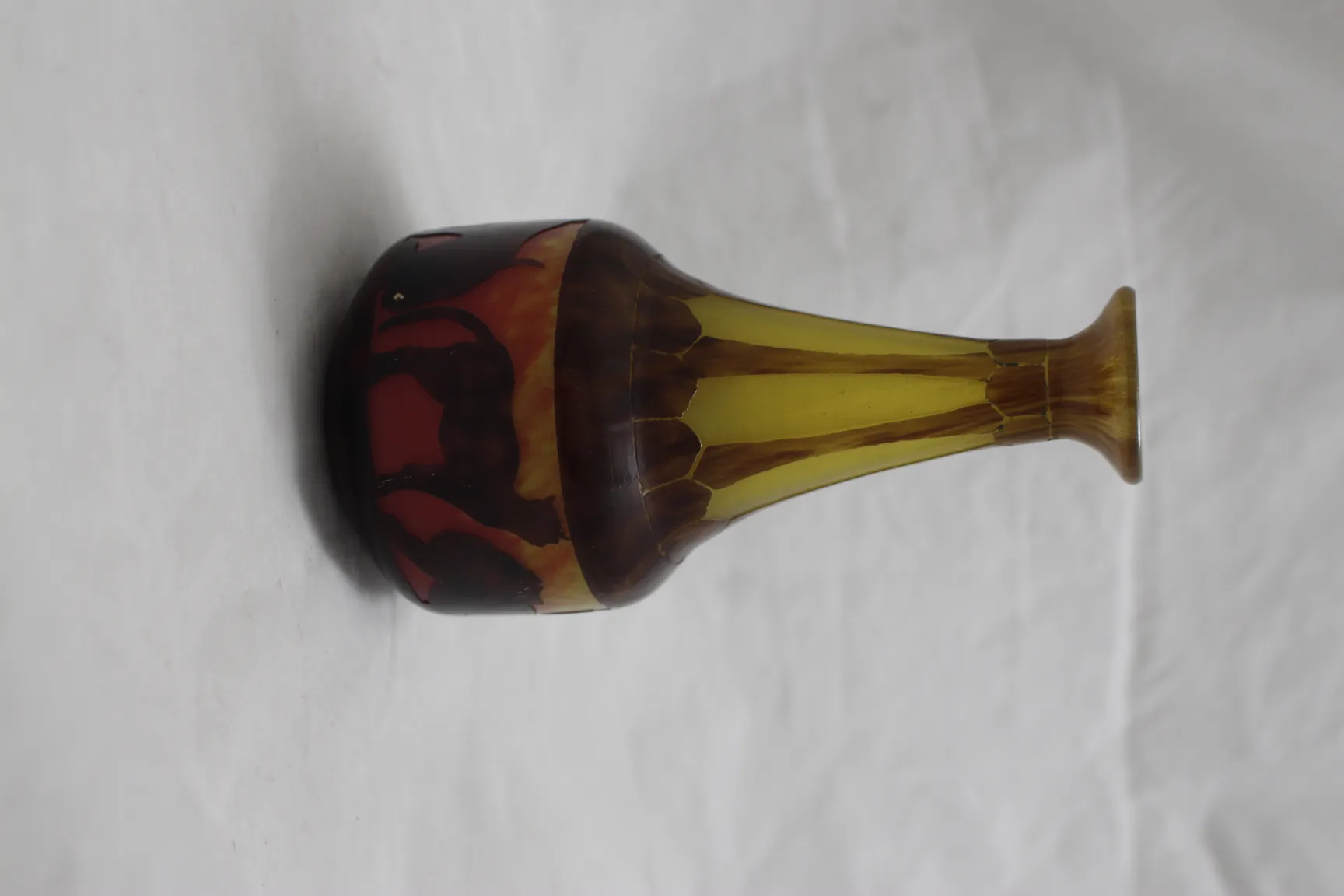 Vidro antigo com assinatura, amarelo e vermelho, design elegante.