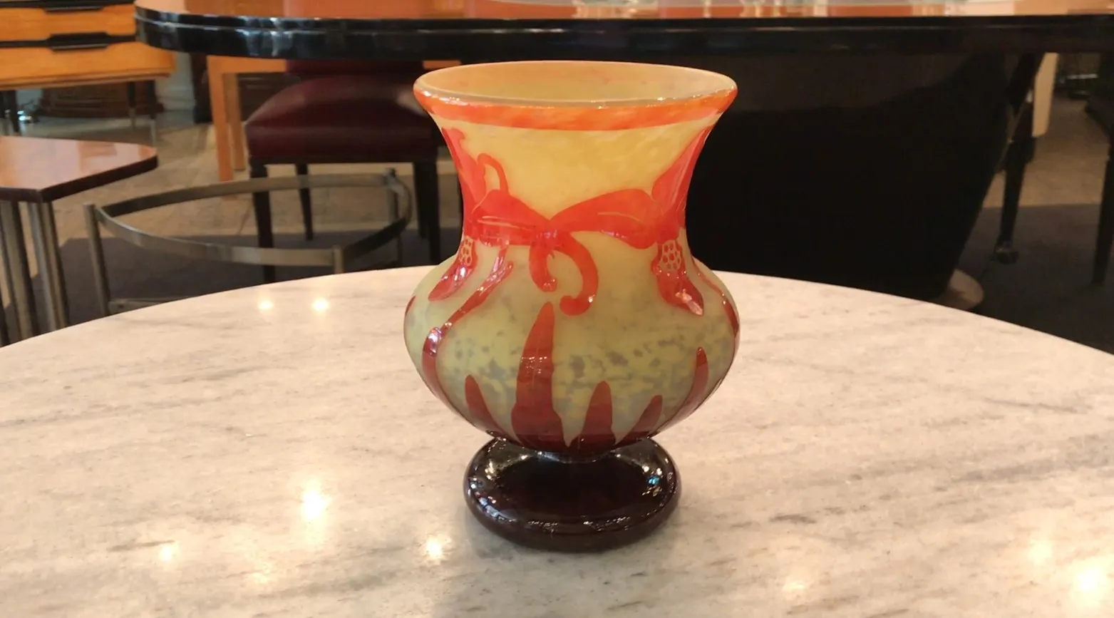 サイン入りグラスLe Verre、淡い背景に赤い装飾的な詳細で、テーブルの上に