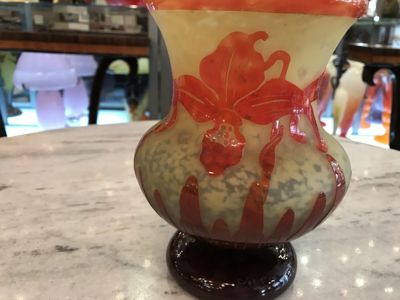 vaso de vidro assinado com design floral em fundo claro