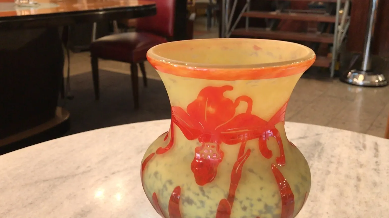 Antique decorative vase, signed glass Le Verre, featuring red and yellow details in a restaurant setting
