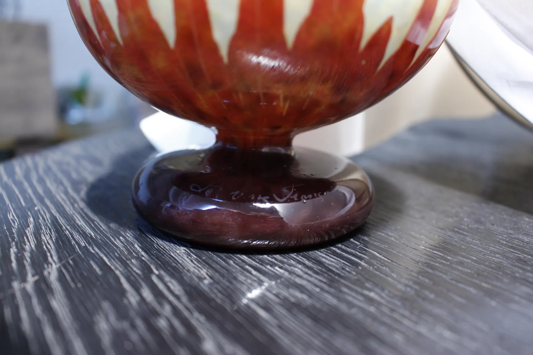 Antikes signiertes Glas von Le Verre auf einem dunklen Tisch.