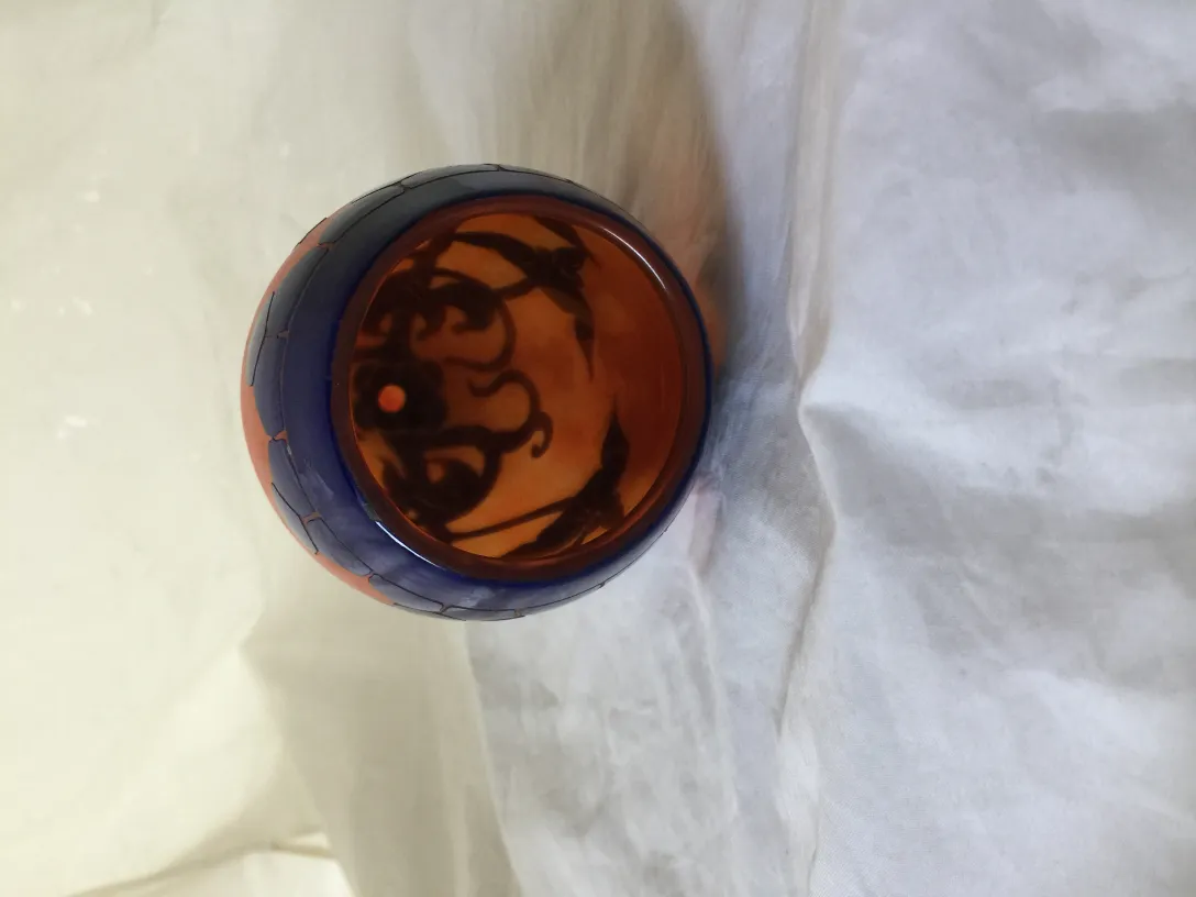 서명된 유리잔(Le Verre)은 복잡한 세부 사항과 따뜻한 색상이 밝은 배경에 있습니다。