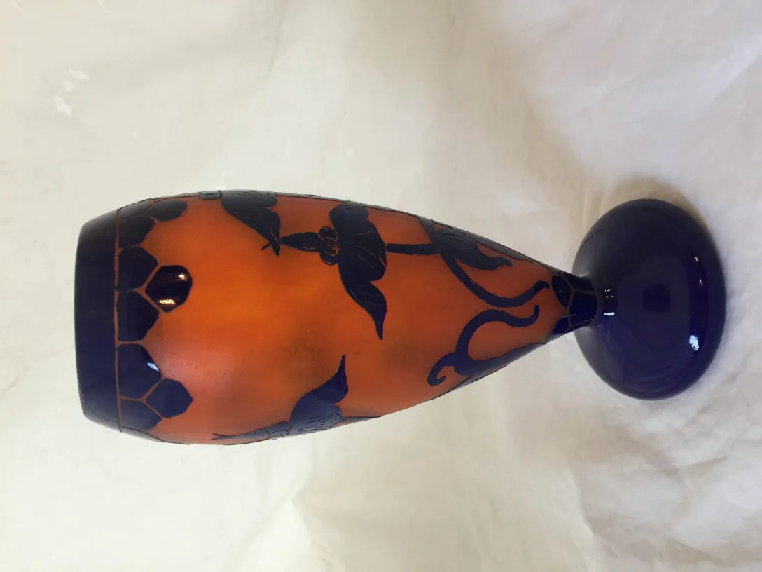 Vidro assinado Le Verre com motivos decorativos em tons de laranja e azul.