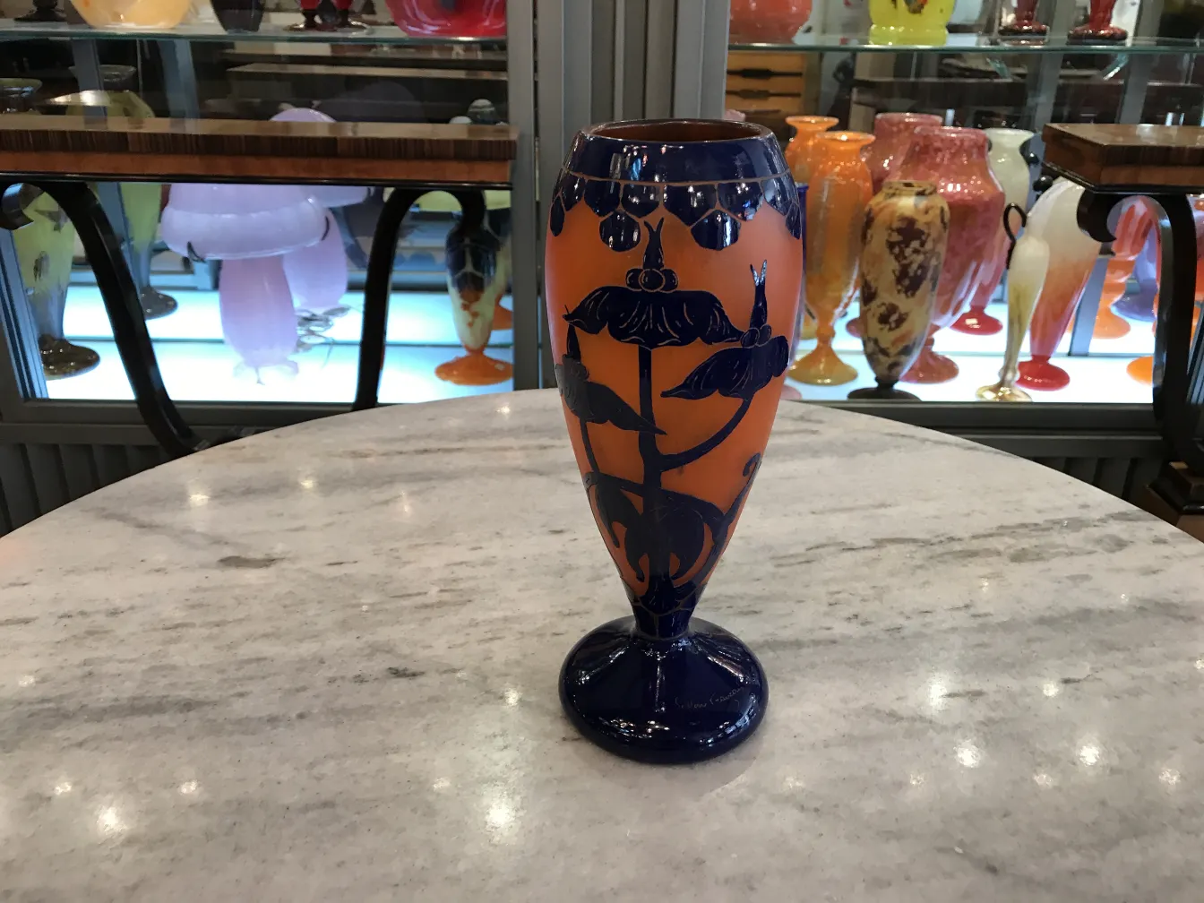 Antiquité de verre avec motif floral en bleu et orange.