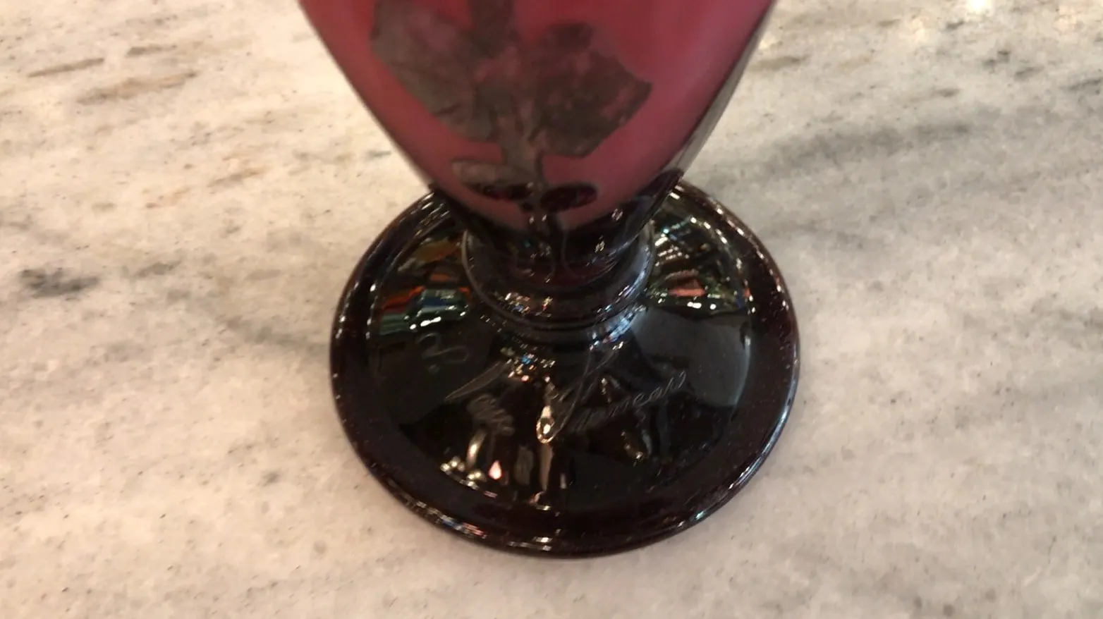 Antikes signiertes Glas Le Verre mit kunstvollem Design vor hellem Hintergrund.