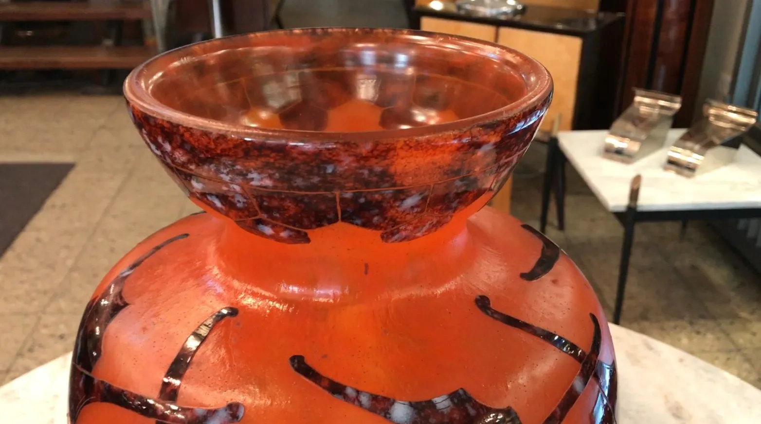 Антикварное подписанное стекло Le Verre, с ярким декором и отличительными узорами, в элегантной обстановке.