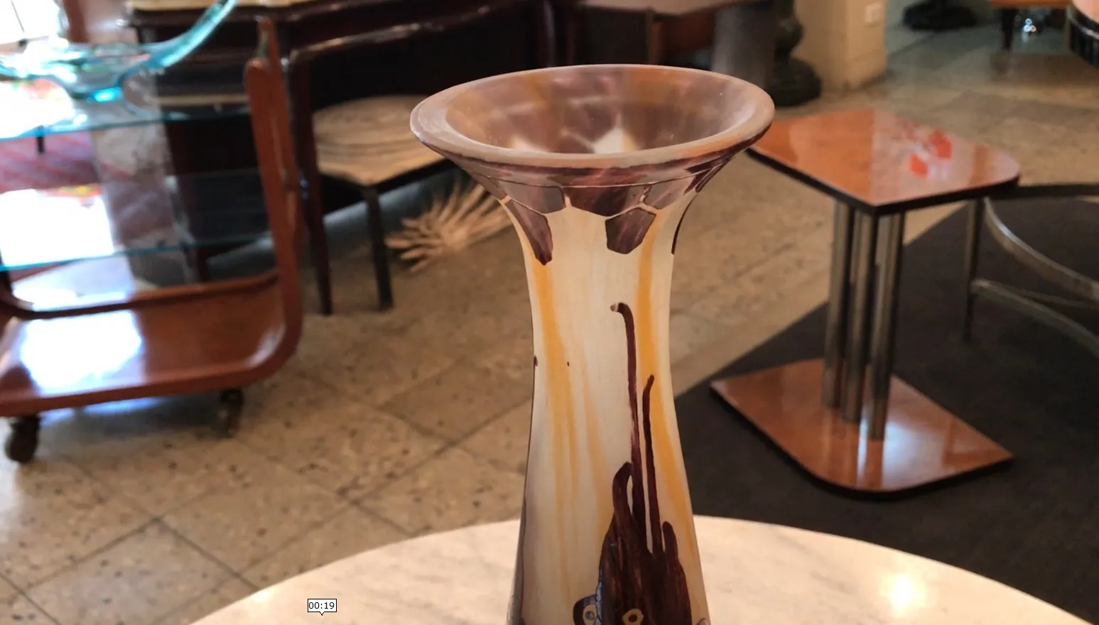 Antico vaso in vetro firmato Le Verre, colori caldi, ambiente accogliente.