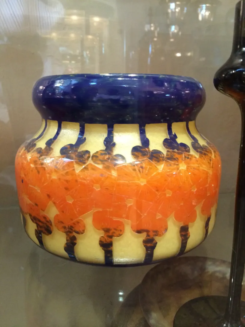 Vase en verre antique avec un design coloré et des détails artistiques.