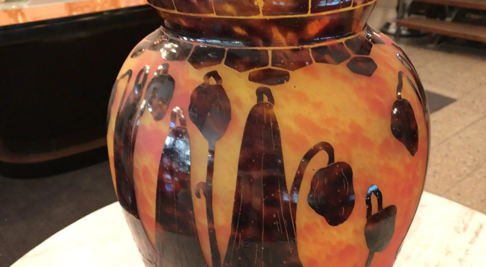 Vaso antigo de vidro com padrão floral em tons quentes