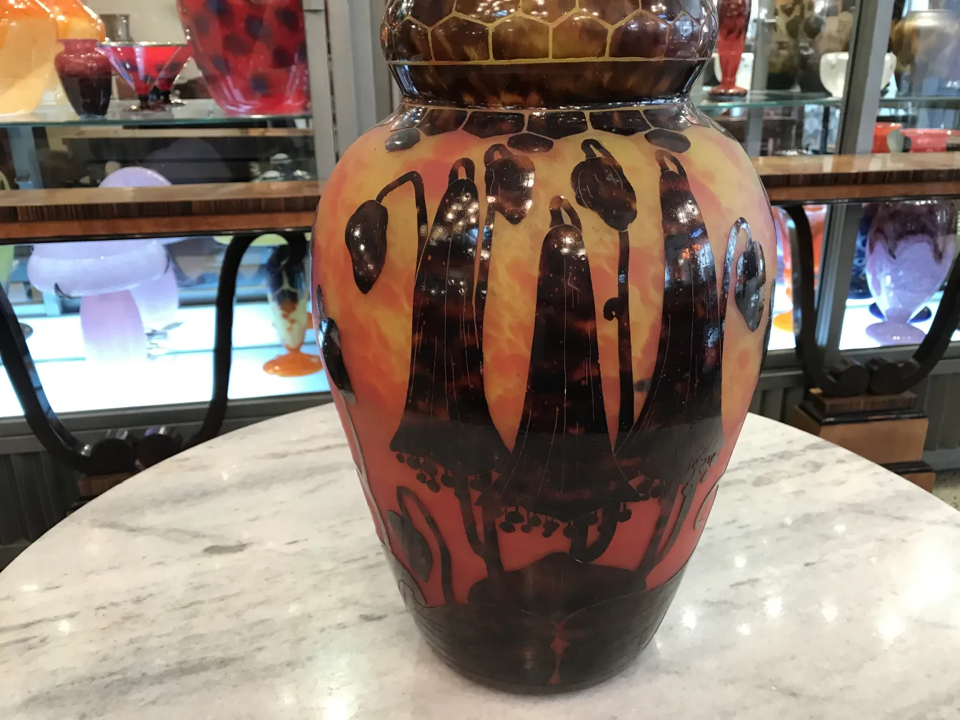 Vaso de vidro assinado com design floral em tons quentes