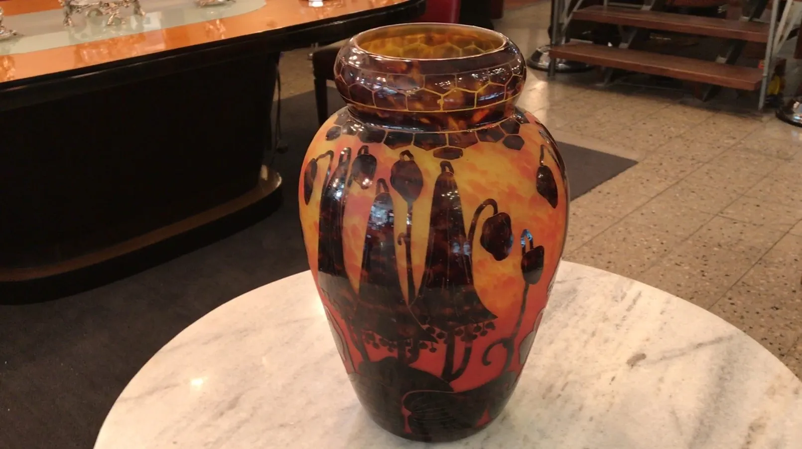 Antike Vase mit Blumenmustern und warmen Farben.