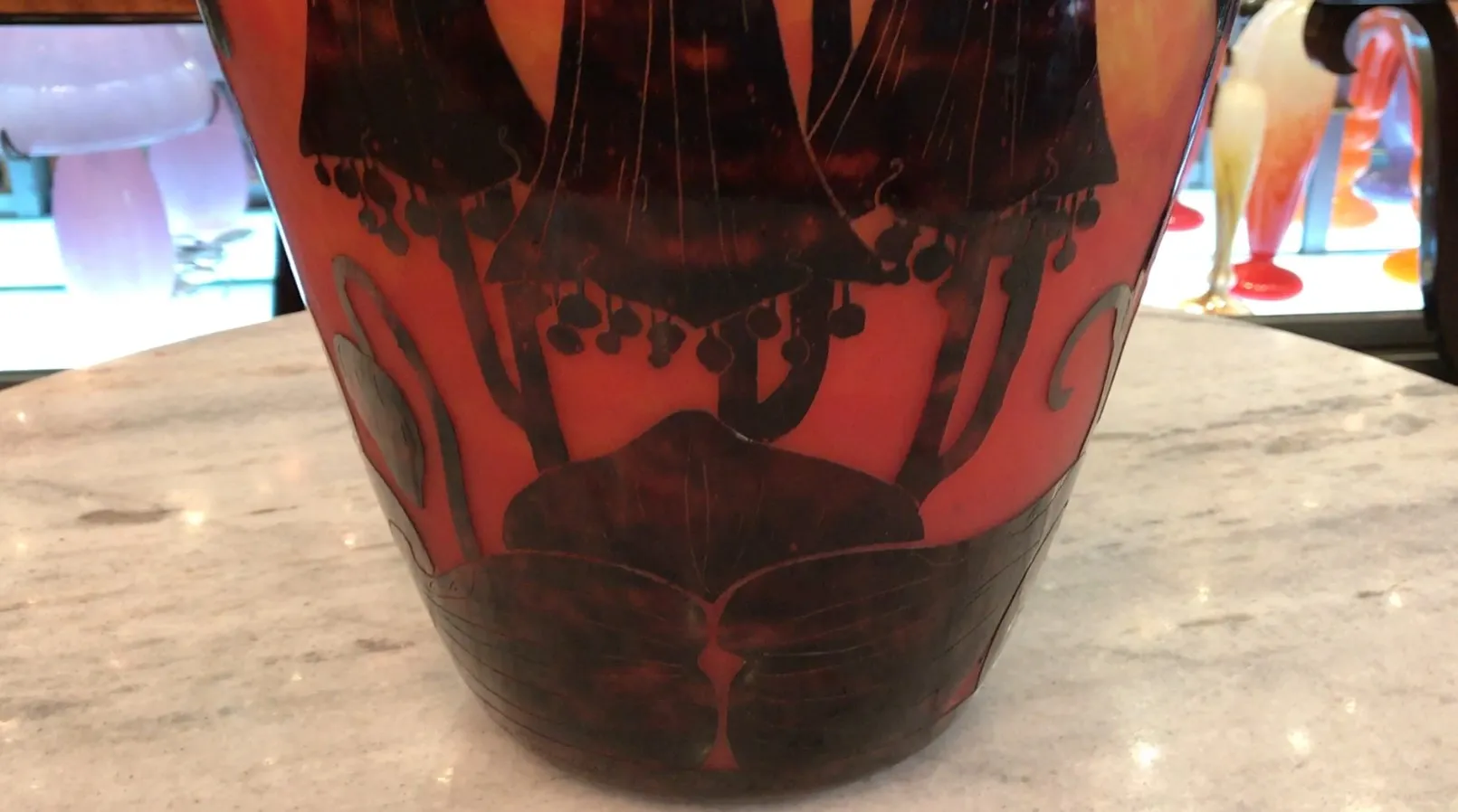 Signed glass featuring red and black detailing, floral decorations