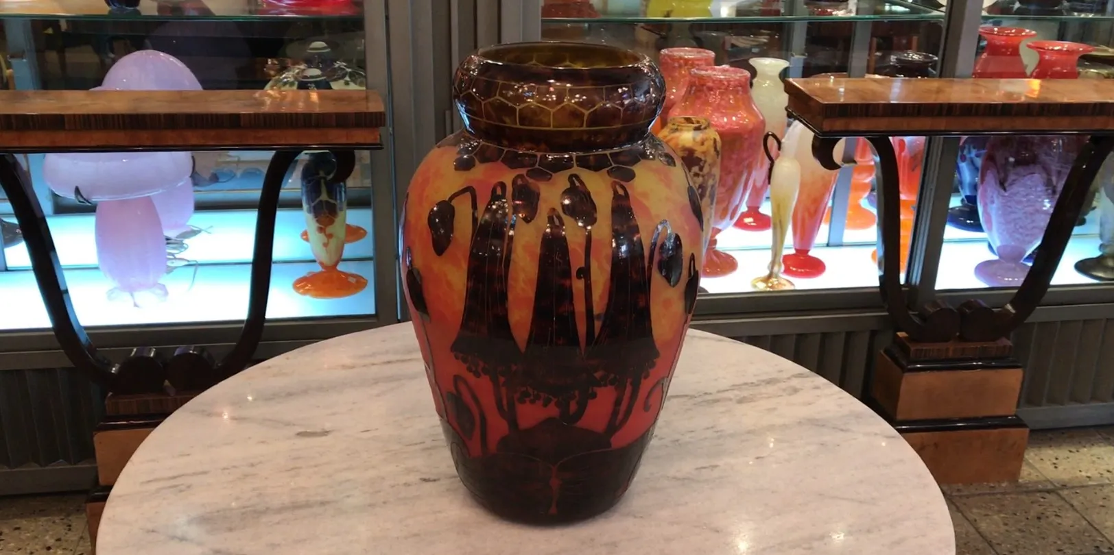 Vaso de vidro colorido com assinaturas e design artístico.