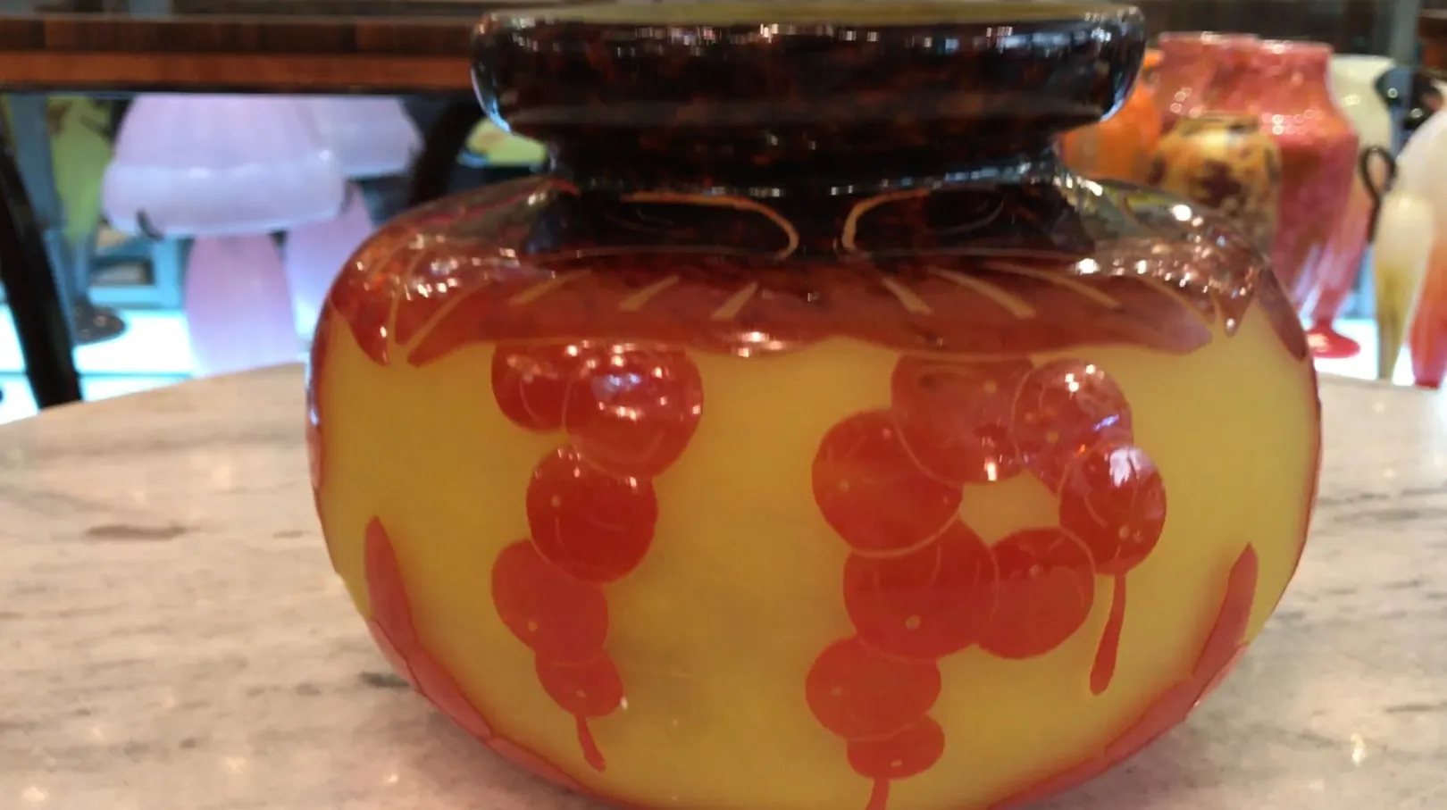 Signed glass Le Verre with colorful design on a table