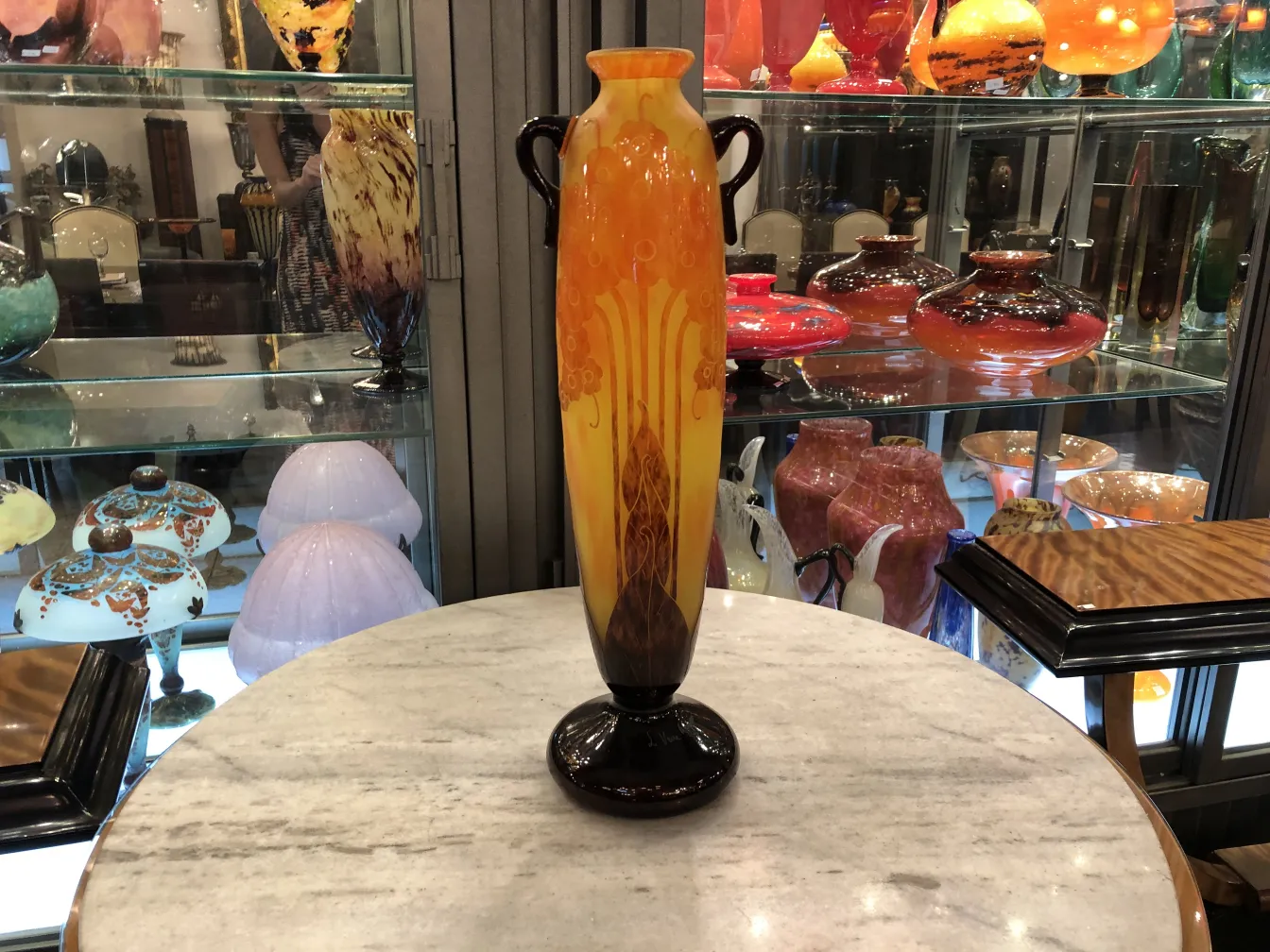 带有橙色和黄色装饰细节的签名玻璃瓶Le Verre，背景多样。