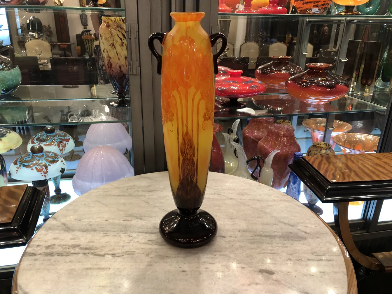 Vase ancien en verre signé Le Verre, avec un design coloré, dans une ambiance d'antiquité.