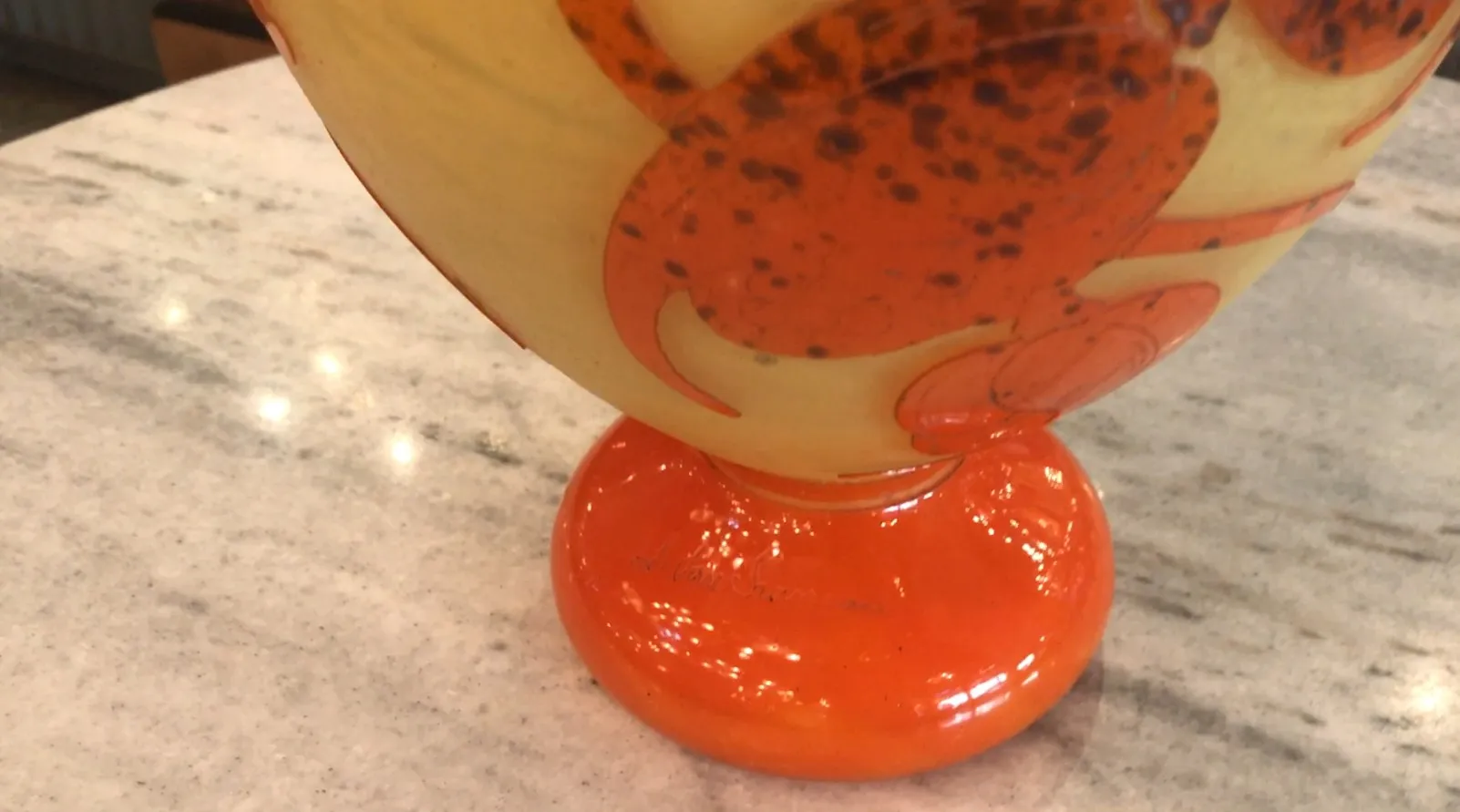 Antiquité verre signé Le Verre avec base orange et motifs.
