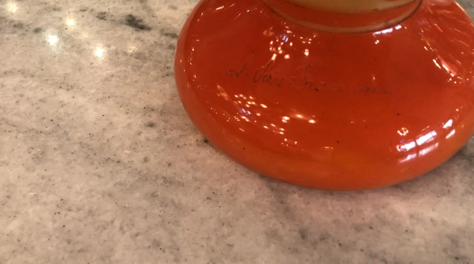 Vidrio firmado Le Verre en color naranja brillante sobre una mesa clara