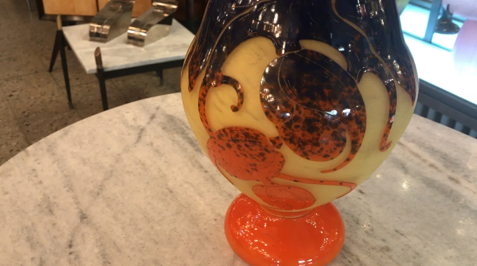 Vetro firmato antico Le Verre con dettagli decorativi caldi, sfondo in marmo e atmosfera moderna.