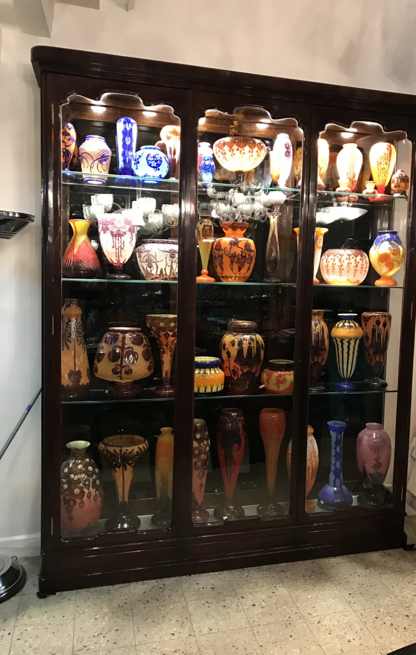 Collezione di antichità con vetro firmato Le Verre in vetrina.