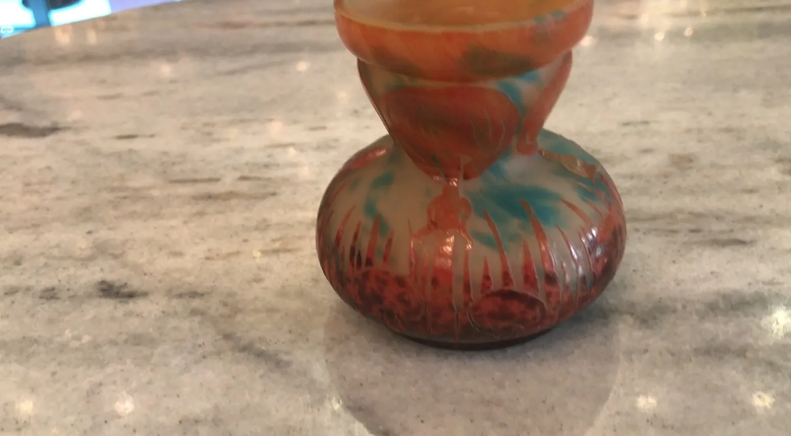 Vidrio antiguo firmado con diseño colorido en un fondo claro