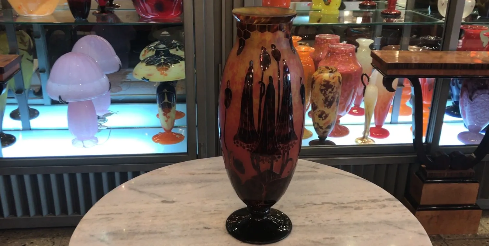 Antike Vase aus signiertem Glas Le Verre mit einzigartiger Dekoration, umgeben von anderen Antiquitäten.