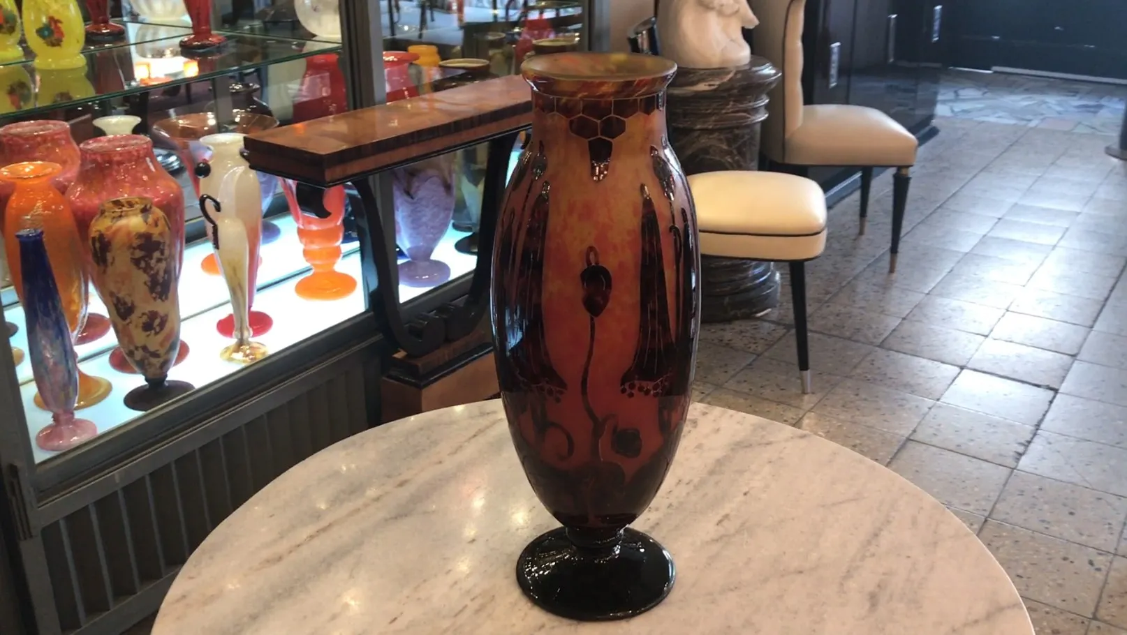 Vaso antigo de vidro assinado Le Verre com detalhes artísticos em um ambiente elegante