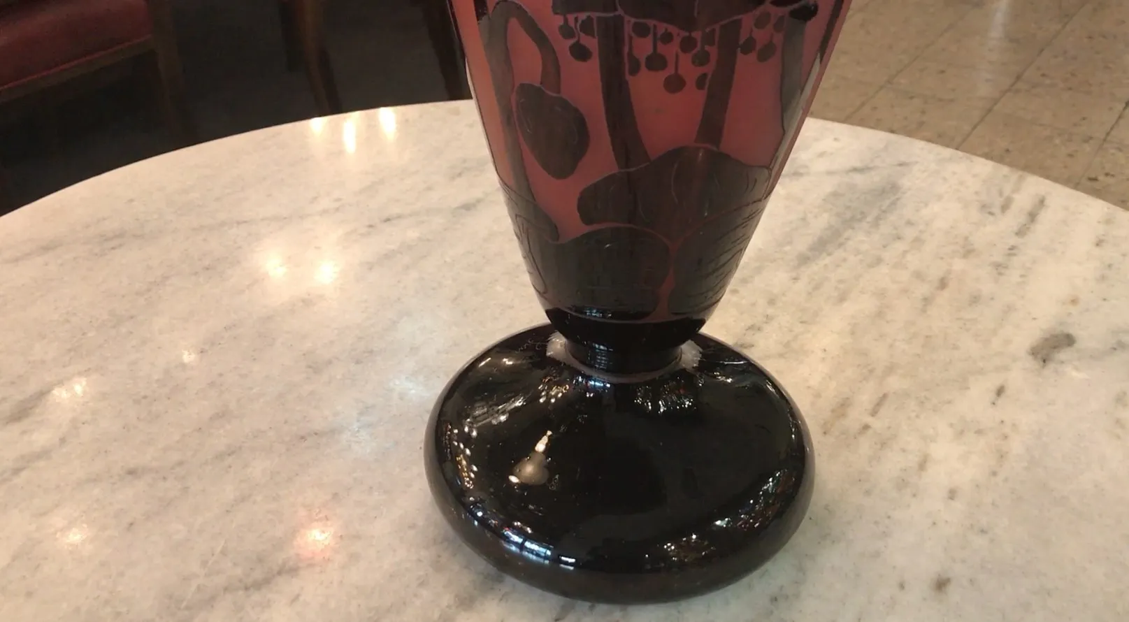 Vidro assinado Le Verre, antigo com design decorativo, fundo escuro.