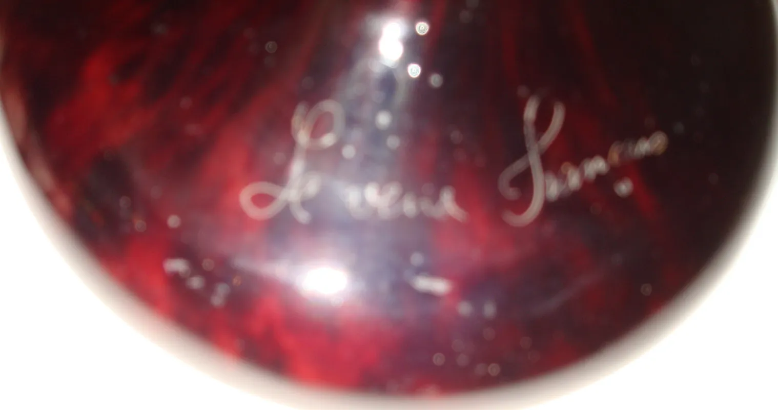 Verre ancien avec signature, détail du design et de la couleur.