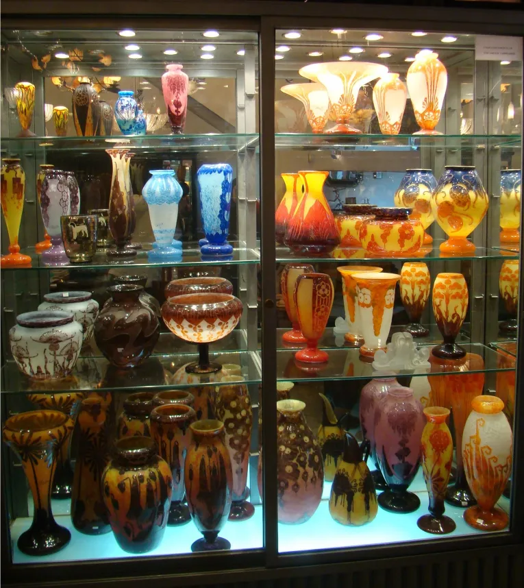 Vasos antiguos de vidrio con diversos colores y formas en exhibición.