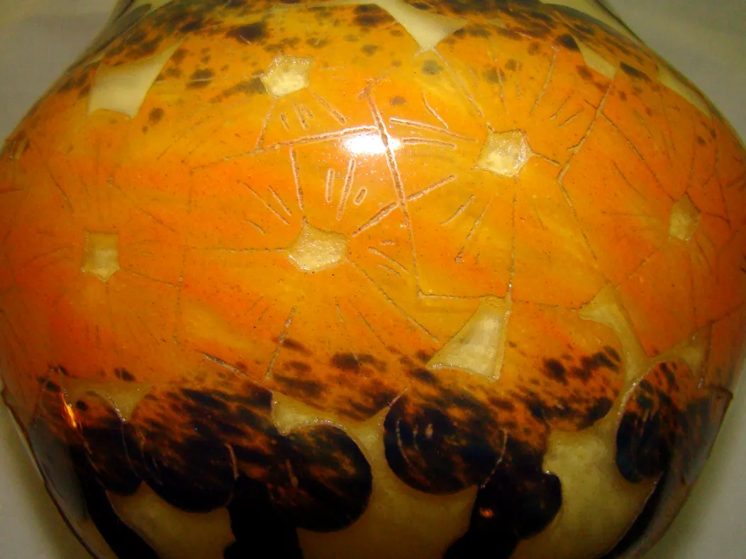 Antikes signiertes Glas mit floralen Verzierungen in orangenen Farbtönen.