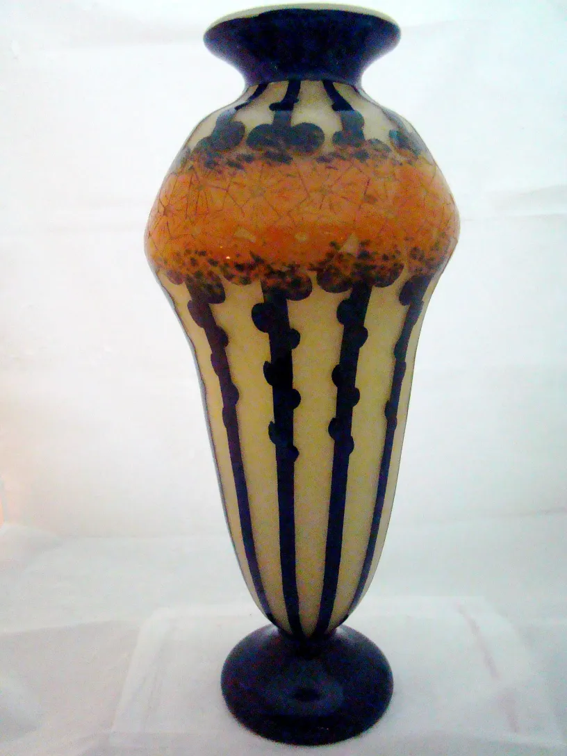 Vaso antico con linee nere e motivi arancioni.