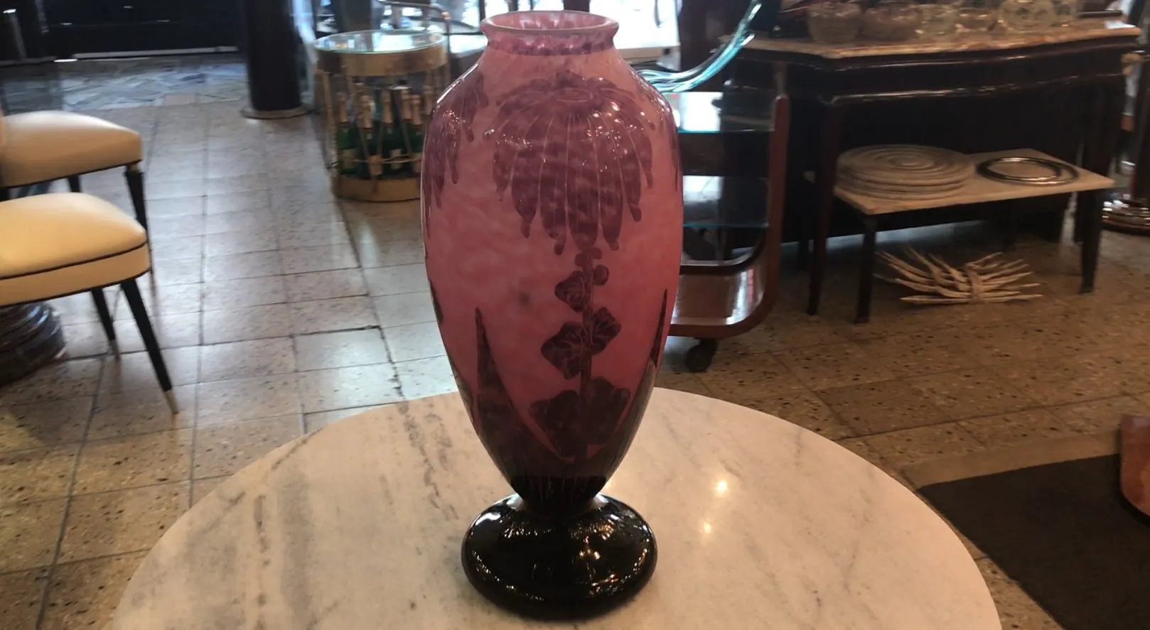 Un vase élégant en verre signé Le Verre avec un design floral en tons roses.