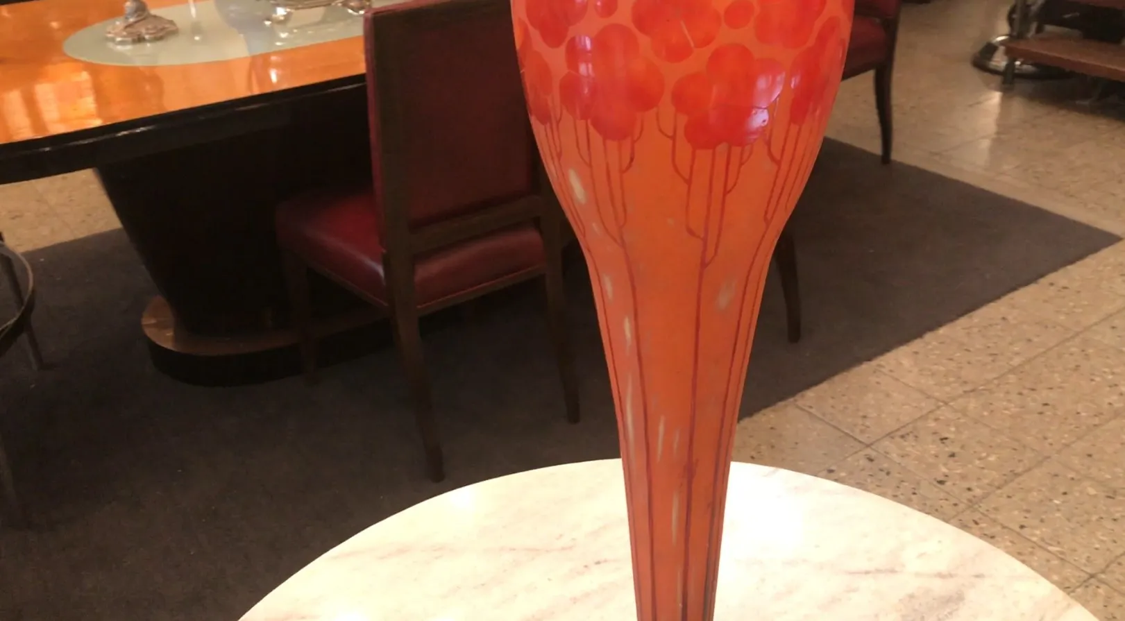 Vase en verre signé Le Verre avec un design vibrant, fond clair, dans un cadre élégant.