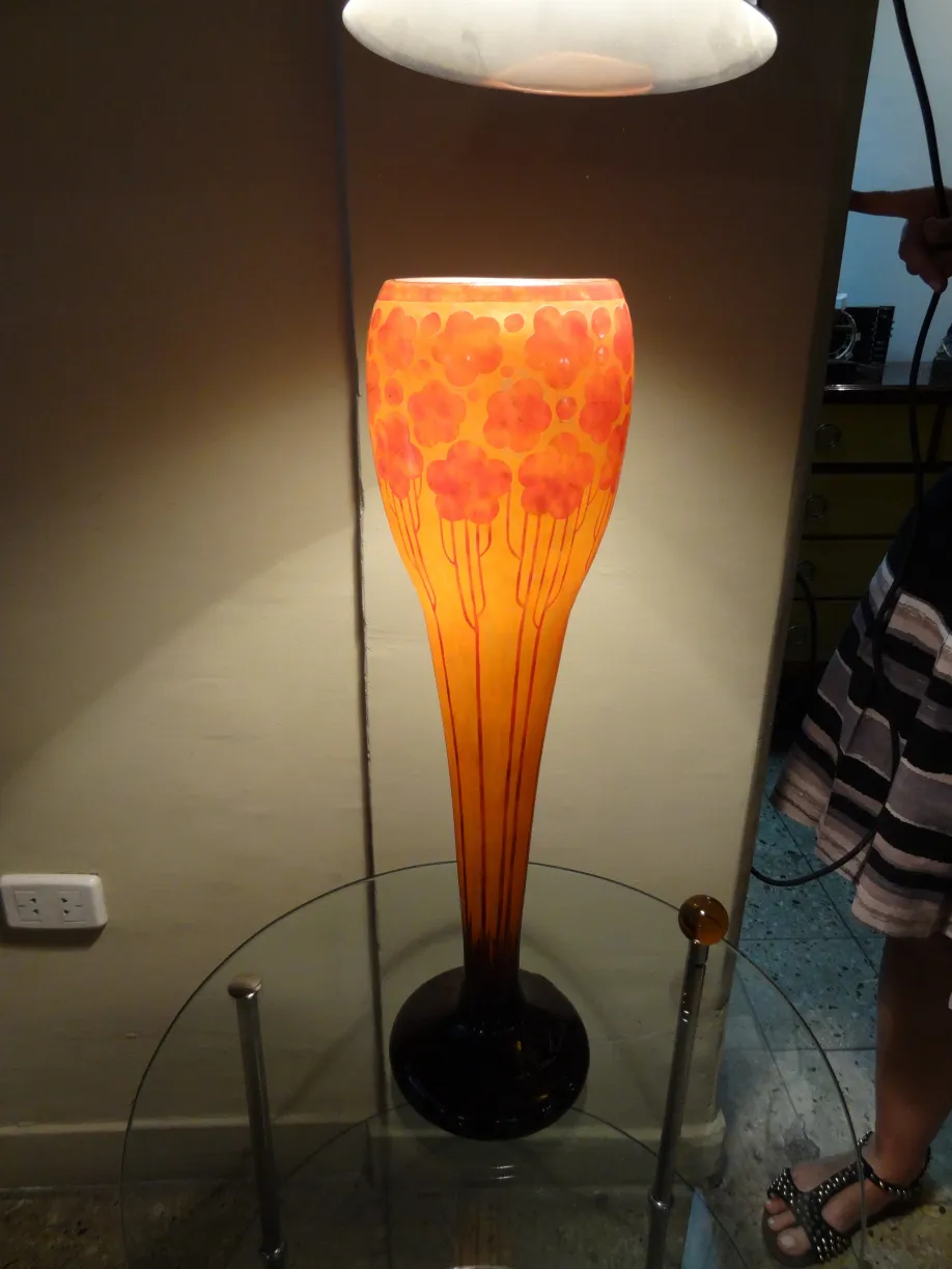 مصباح زجاجي موقّع le verre بتصميم زهري بألوان دافئة.