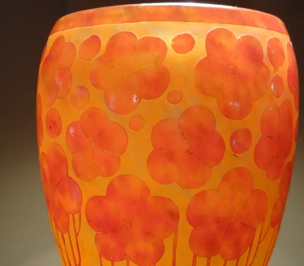 Verre signé Le Verre avec des fleurs oranges sur fond jaune.