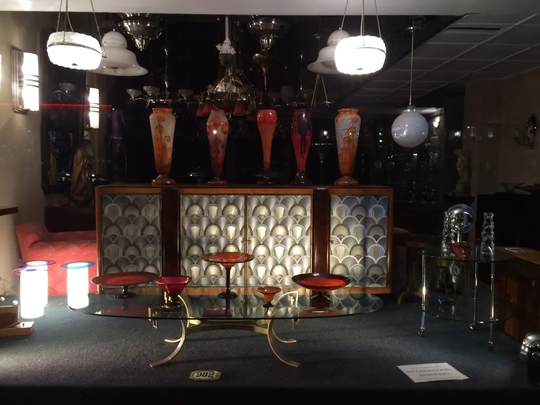 Exhibición de antigüedades con vidrio firmado Le Verre, decorativo y atractivo.