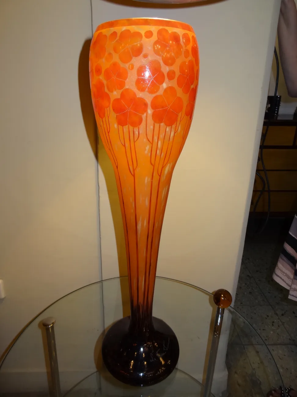 Decorative glass lamp in orange tones with flower engravings.