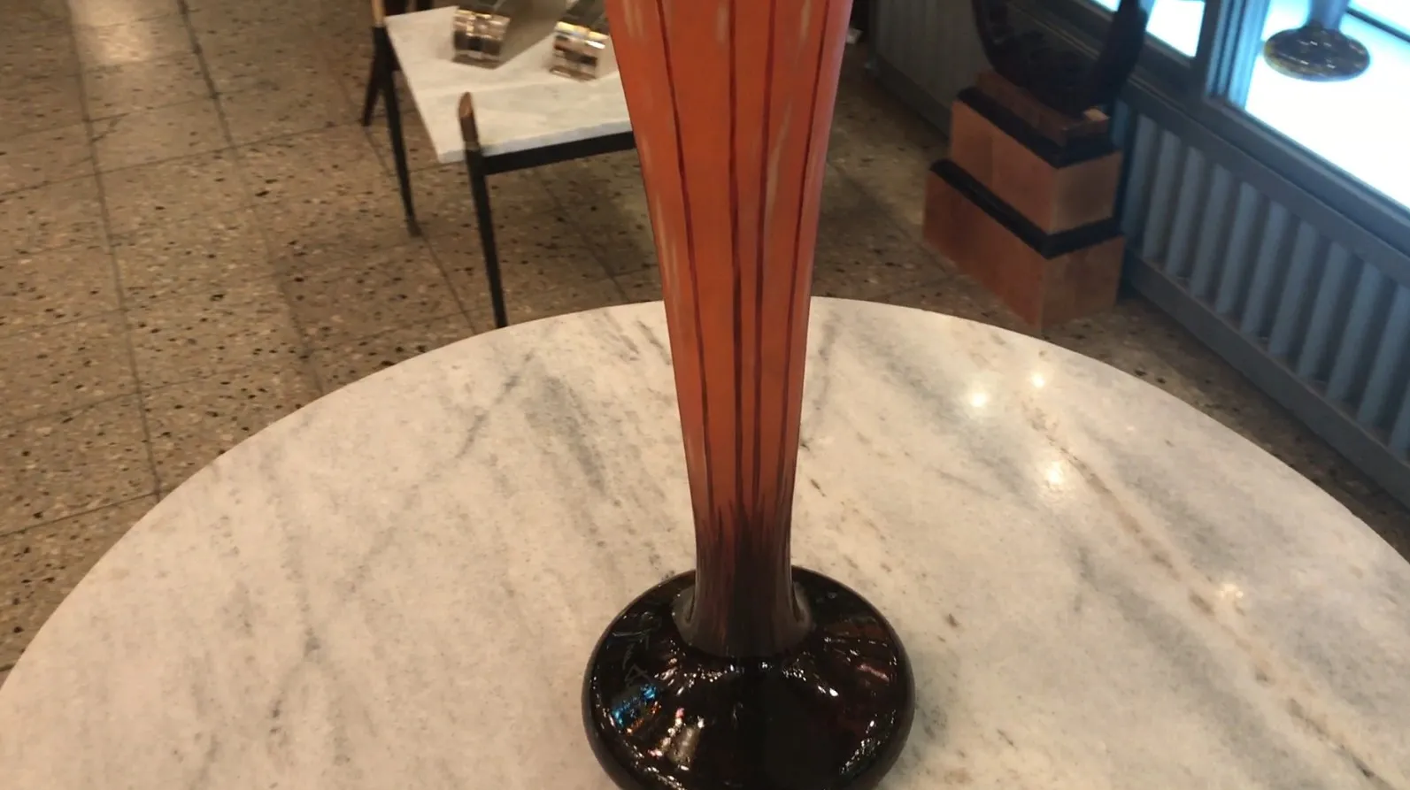 عرض زجاج موقّع قديم (Le Verre) في بيئة أنيقة.