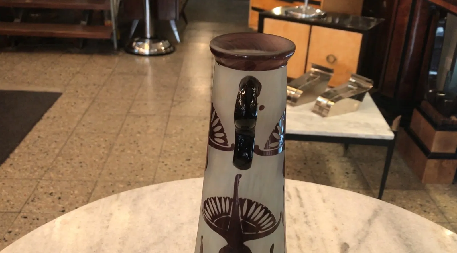 Vidro antigo com detalhes decorativos e sombra de mesa.