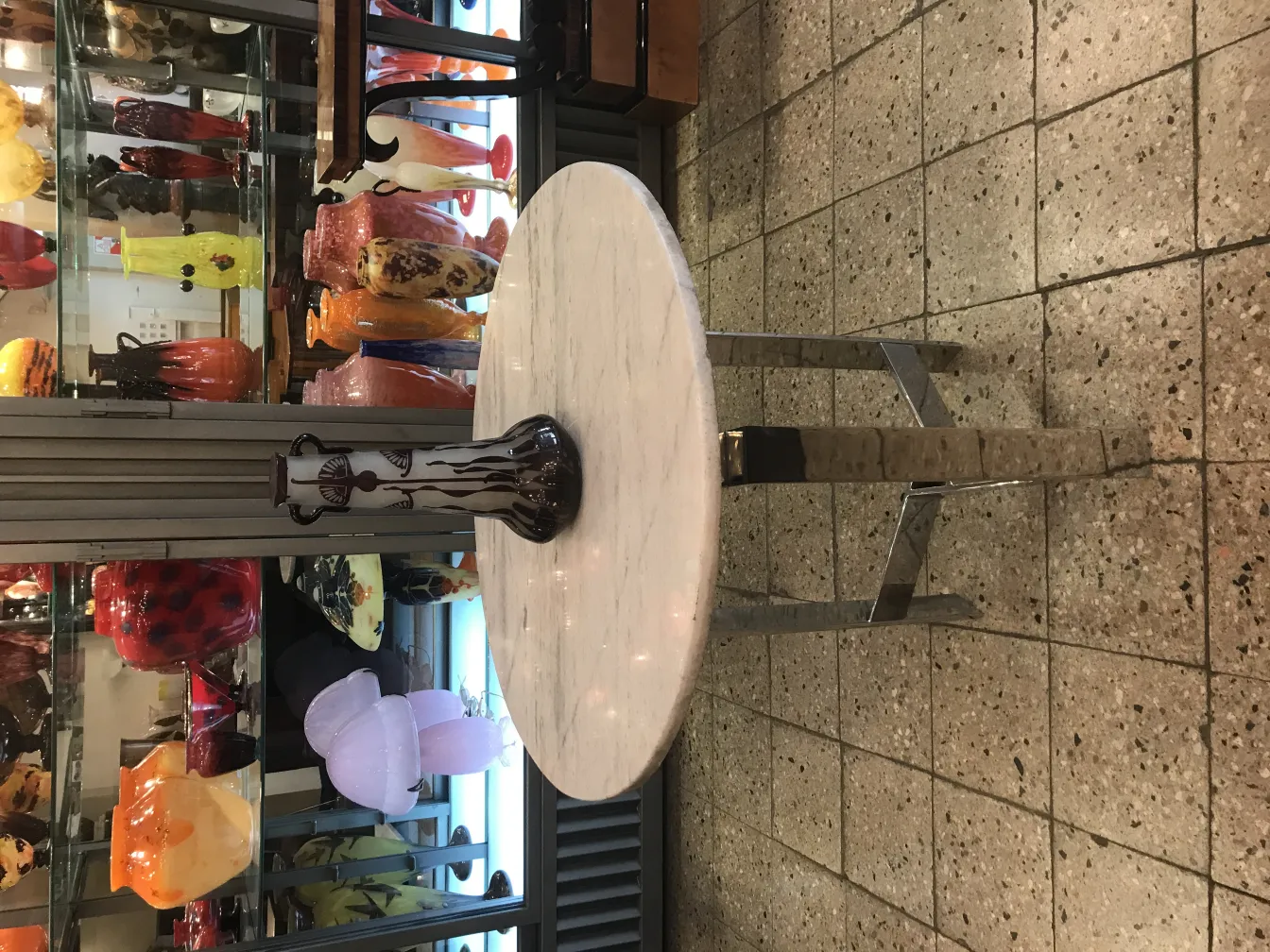 Vidro assinado Le Verre decorativo em um ambiente antigo com outros itens de vidro.