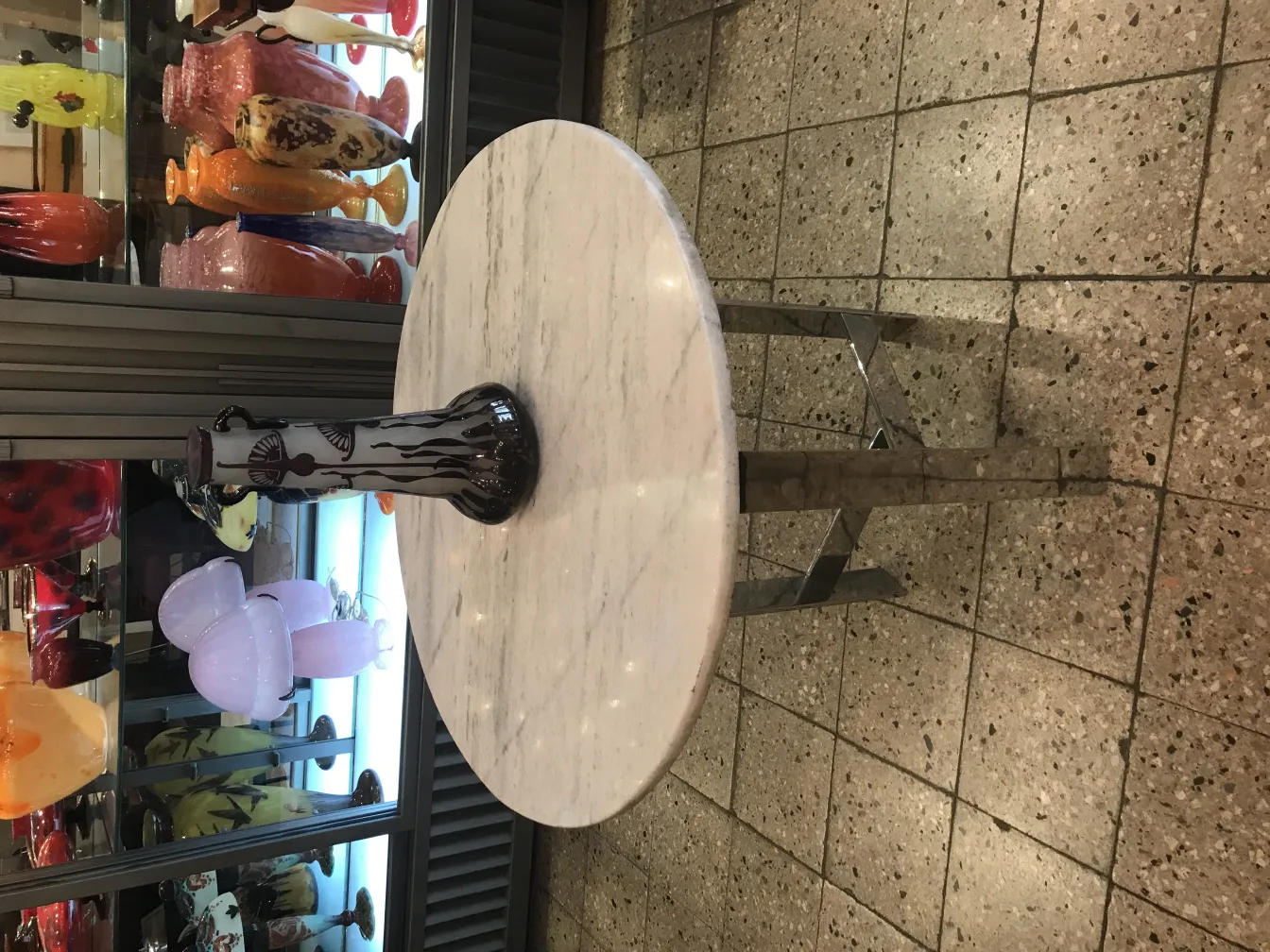 Vidrio firmado Le Verre con decoración artística en el fondo.